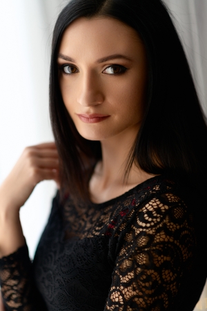 Brunette woman posing near window at the morningの写真素材