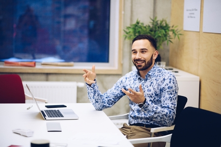 Young caucasian businessman gesturing during discussion in his office. Man working in officeの写真素材