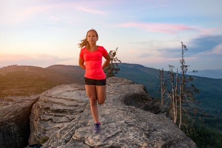 Woman cross country runner quads stretching in mountains at summer. Woman running. Silesian Beskid, Szczyrkの写真素材