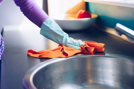 Young woman cleaning kitchen cabinets. Spring cleaningの写真素材