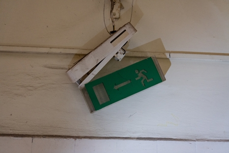 Old broken evacuation route signの写真素材