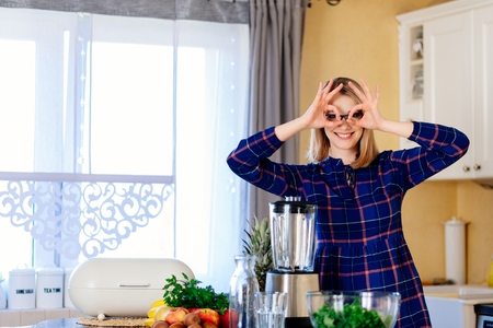 Woman having fun in kitchen. Woman preparing delicious healthy smoothieの写真素材