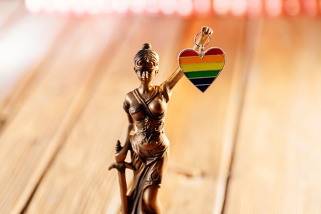 Statue of Temide - symbol of law and justice holding heart with lgbt colours. Lgbt rights and lawの写真素材