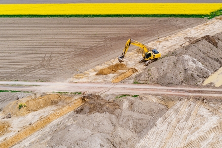 Aerial drone view on excavator working on building site. Road constructionの写真素材