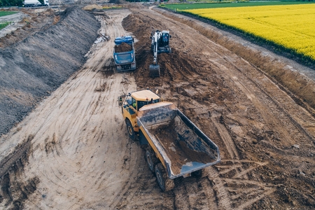 Aerial drone view on excavator loading sand on tipper truck. Road constructionの写真素材