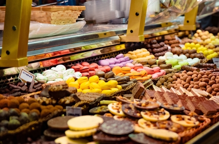 Colorful macaron cakes and other delicious cakes on display in candy storeの写真素材