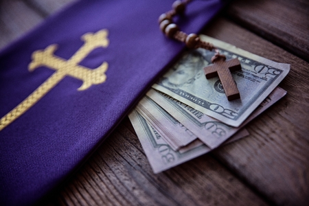 Wooden rosary and catholic church symbols and money. Church and moneyの写真素材