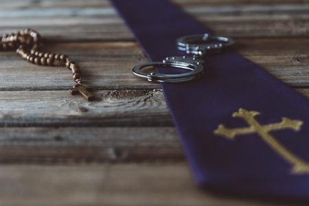 Handcuffs and catholic church symbols. Church and crimeの写真素材
