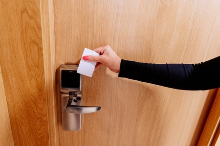 Woman opening hotel room doors with electronic key cardの写真素材