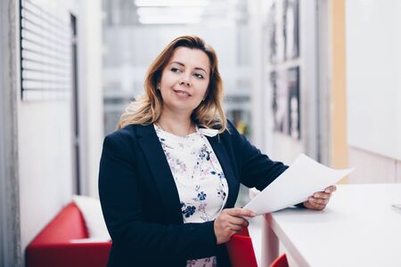 40 years successful business woman standing in the officeの写真素材
