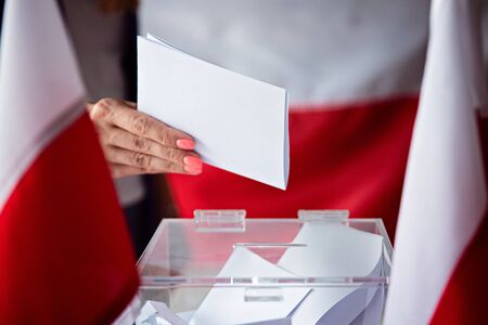Woman putting her vote to ballot box. Poland political electionsの写真素材