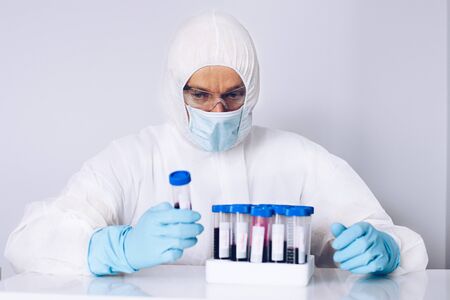 Scientist in laboratory working with test blood tubes.の写真素材