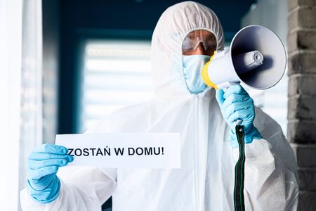 Medic holding card with message Stay at home in Polish languageの写真素材