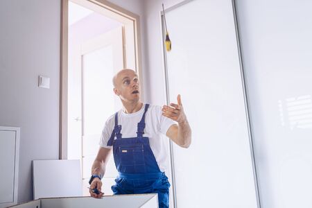 Professional who assembles furniture at home plays with a screwdriver.の写真素材