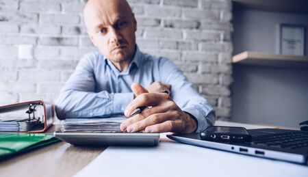 Financial problems during crisis. Man manager with calculator counting money and bills.