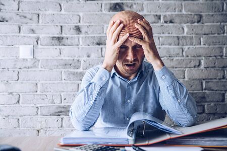 Finacial problems and crisis. Stressed depressed man reading bills and loan contract. Finacial...