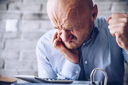 Financial or health problem, stressed man in the office
