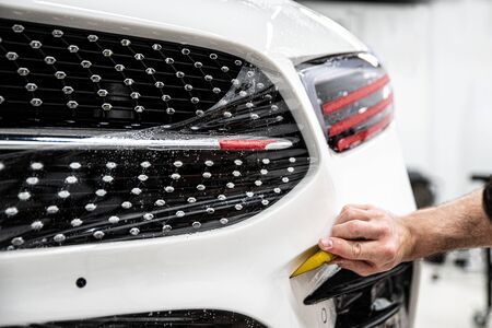 Car wrapper applying protective transparent foil on car body.の写真素材