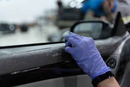 Car detailing worker cleaning car interior doorsの写真素材