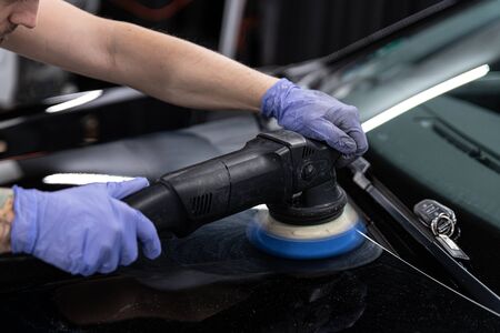 Car detailing studio worker polishing car paintの写真素材