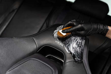 Man in rubber gloves cleaning leather car seatの写真素材