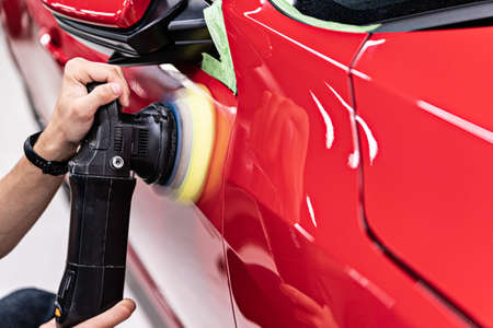 Man polishing car varnish with hand electric polisher.の写真素材