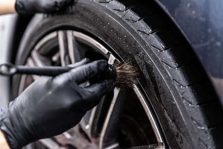 Car detailing studio worker cleaning car wheel with special brush.の写真素材