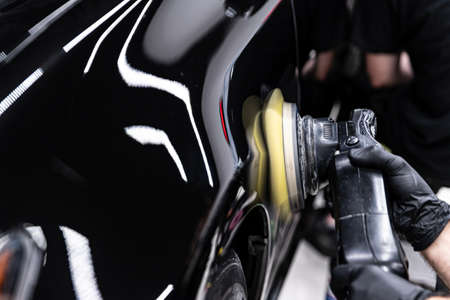 Car detailing studio worker polishing car varnishの写真素材