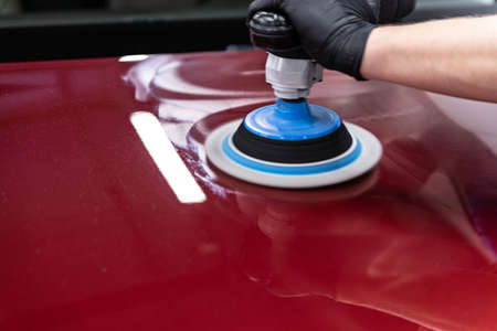 Car detailing studio worker polishing car varnishの写真素材