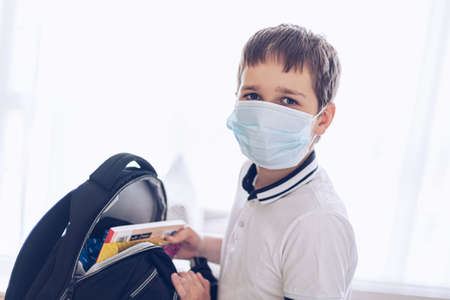 Child boy packing his school backpack at home.の写真素材