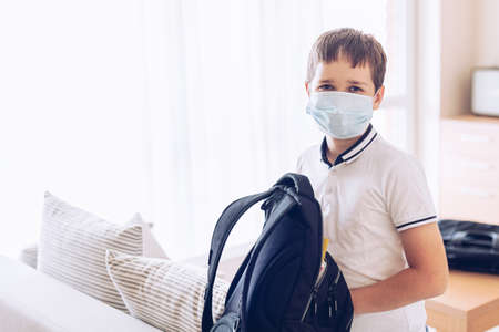 Child boy packing his school backpack at home.の写真素材
