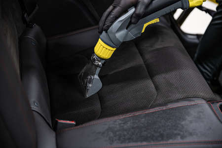 Man car wash worker cleaning and washing car interiorの写真素材