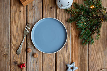 Christmas decoration with empty plate and fork on wooden tableの写真素材