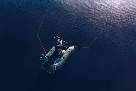 Aerial view of fishermen in a fishing boat in the middle of the lake.の写真素材