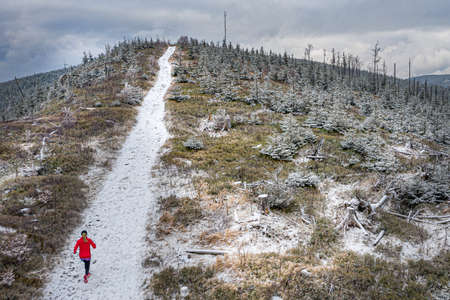 Drone view of a woman runner on a mountain trail in a red sweatshirt. Inspiration and motivation.の写真素材