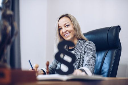 Smiling, satisfied female lawyer notary is working in her notary office.の写真素材