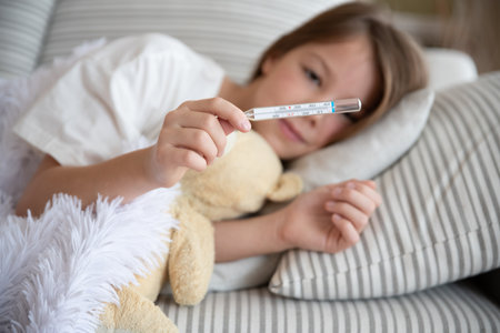 The girl is sick. He is holding a thermometer in his hand.の写真素材