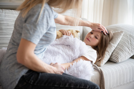 The mother checks her sick daughter for fever.の写真素材
