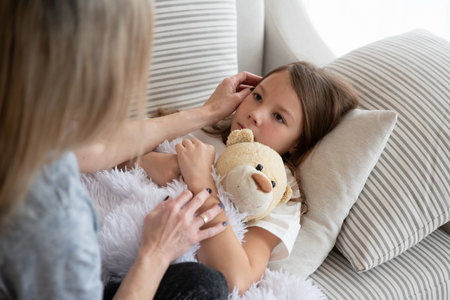 A tender mother looks after her sick daughter.の写真素材