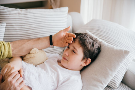 Father caring for sick son lying.の写真素材