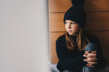 Sad girl on the looking out window.の写真素材