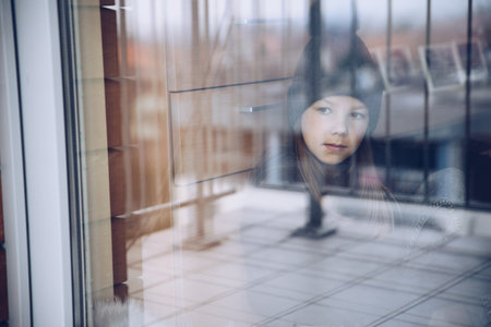 Melancholy and sad girl looking out the window.の写真素材