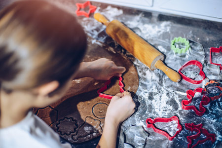 The girl prepares gingerbread cookies with a plastic mold.の写真素材