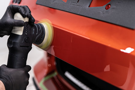 Car detailing studio worker removing scratches and polishing carの写真素材