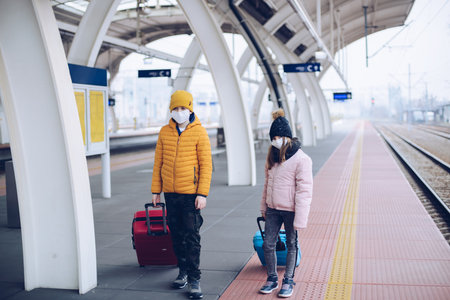 The children are standing on the platform of the train station. They want to go on winter holidays.の写真素材