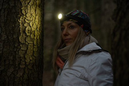 Beauty tourist woman with headlight in the forestの写真素材