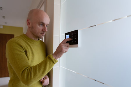 A handsome man sounds the alarm before he leaves the house.System concept for crime prevention.の写真素材