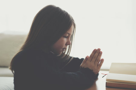 A beautiful girl with long hair is praying at home.の写真素材