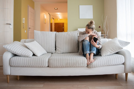 Depressed lonely unhappy mental woman sitting alone on the sofa.の写真素材