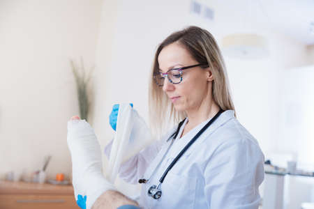 Professional nurse bandaging the patients leg with a medical bandage.の写真素材